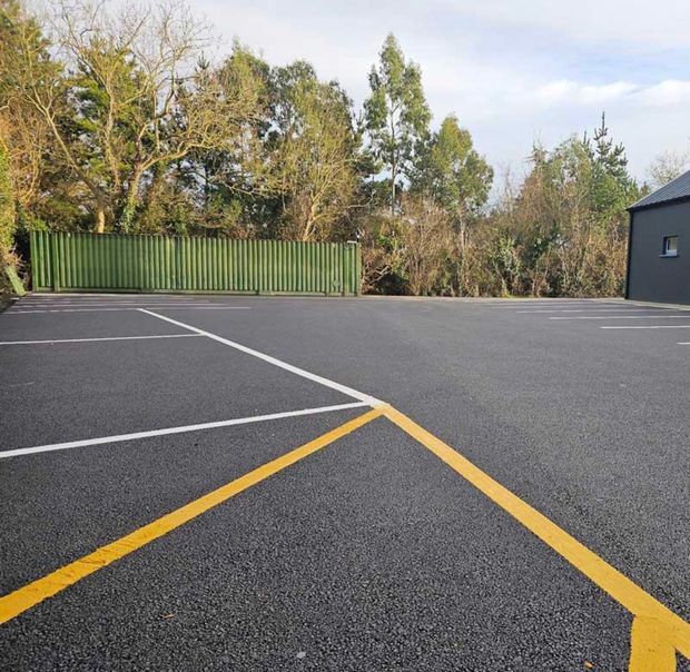 Car park with freshly sprayed white parking bays and a yellow line