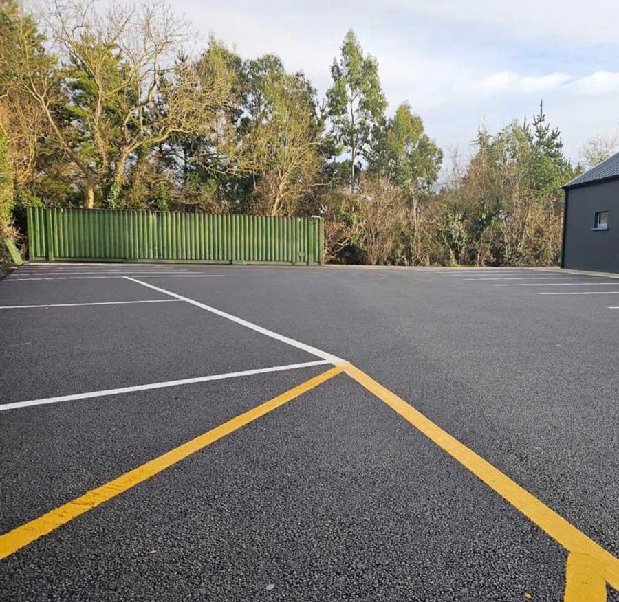 Car park with freshly sprayed white parking bays and a yellow line
