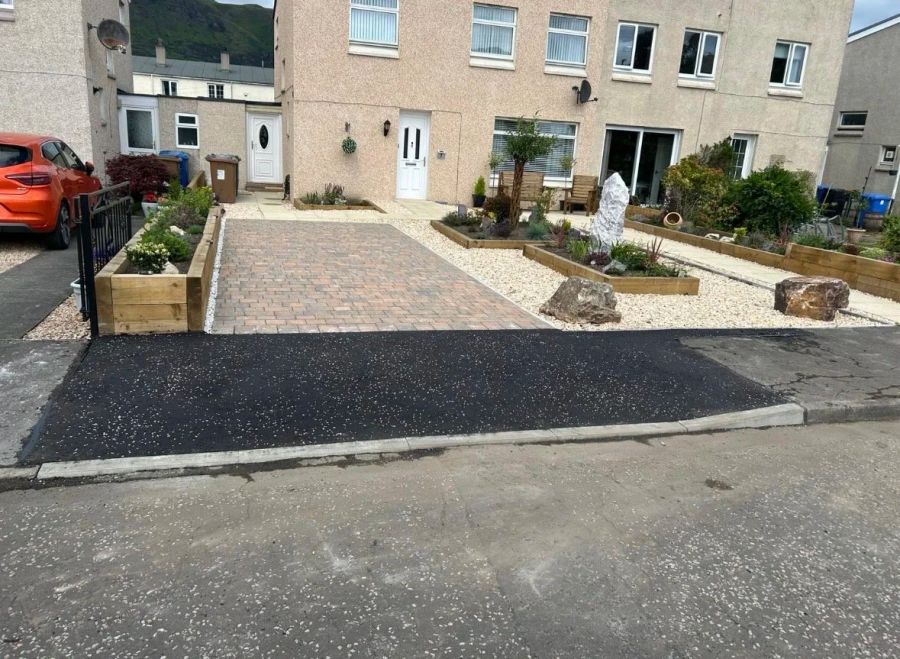 Tarmac dropped kerb crossing running from the road up to a block paved driveway