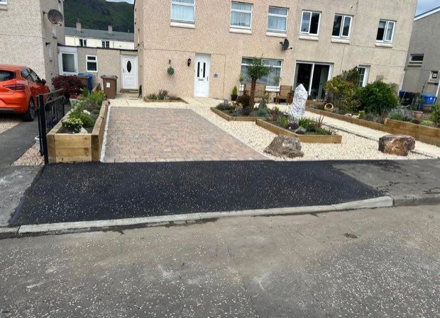 Wide tarmac crossing running from a driveway to a lowered kerb at the road