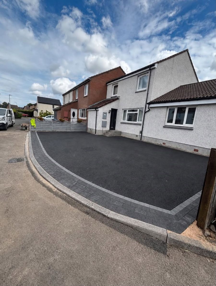Newly laid tarmac driveway edged with a grey block paved border