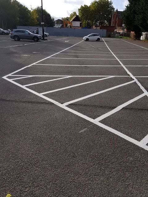 Car park with white hatched markings and parking bays freshly painted